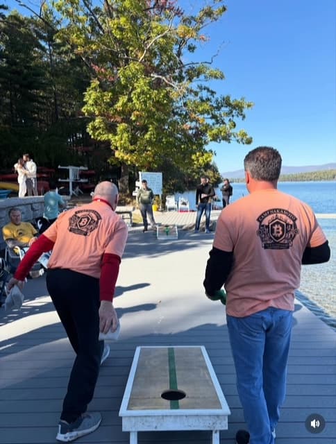 Campers playing cornhole by the lake