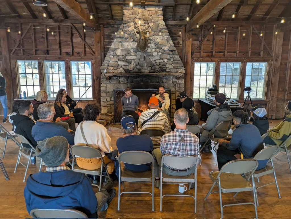 Fireside chat by the stone hearth at Camp Nakamoto