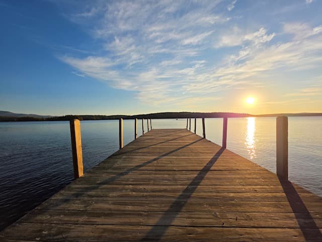 Dock stretching into Lake Winnipesaukee at sunset